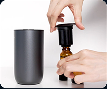Twisting the 15 millilitre oil bottle off the atomiser head to refill it
